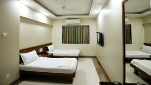 A hotel room with two single beds, a flat-screen TV, an air conditioning unit, and a window with curtains. - Hotel Bombay International (Mumbai)