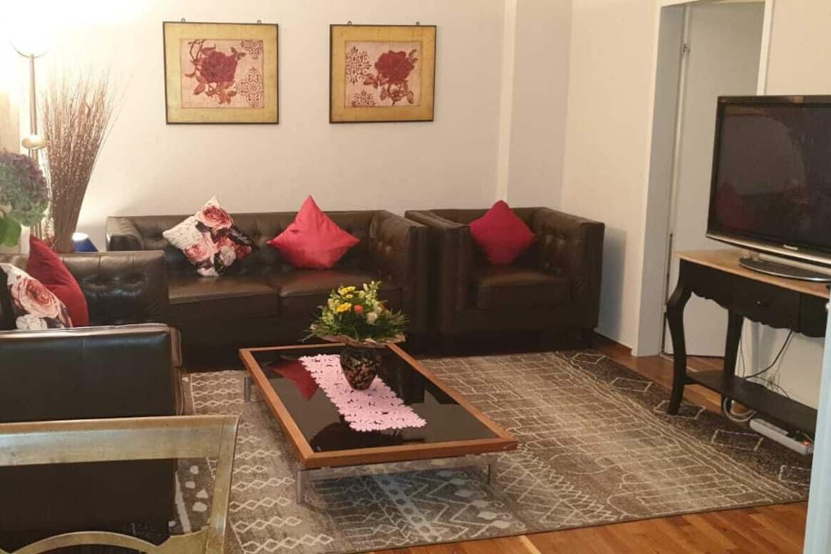 A living room with a sofa set, a coffee table, and a television.