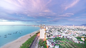 Un paysage urbain côtier comprenant une plage, une zone résidentielle et une route menant à la plage.