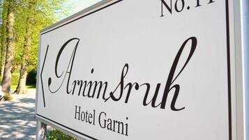 Un letrero que indica 'Amim Srukh Hotel Garni' con el número 'No.11'.