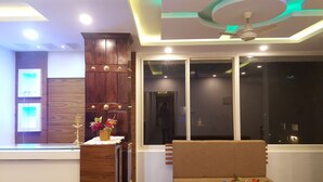 A modern living room with a wooden cabinet, a sofa, and a large window. - Tree Blanche Munnar (Devikolam)