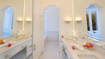 A modern bathroom with two sinks, large mirrors, and a view of a pool.