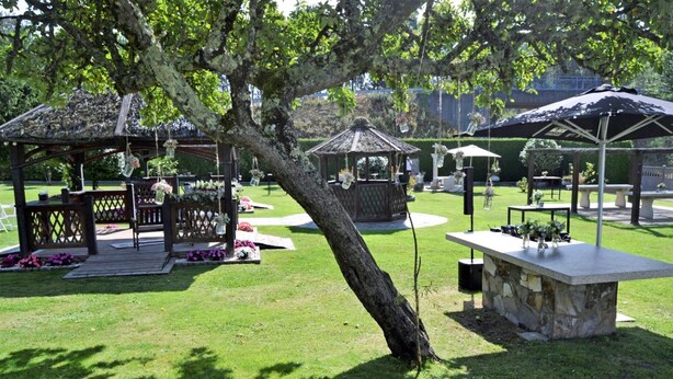 Un belvédère, des sièges extérieurs et une table en pierre, le tout situé dans un parc.