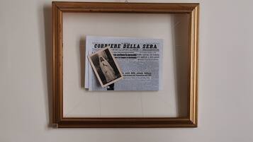 A framed newspaper article titled "CORVERE DELLA SERA" with a small photograph on top.