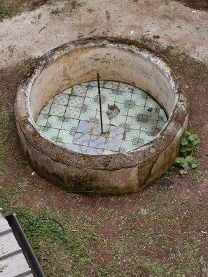 A circular outdoor structure with a tiled floor, surrounded by a concrete ring. - Artisan Maison (Palermo)