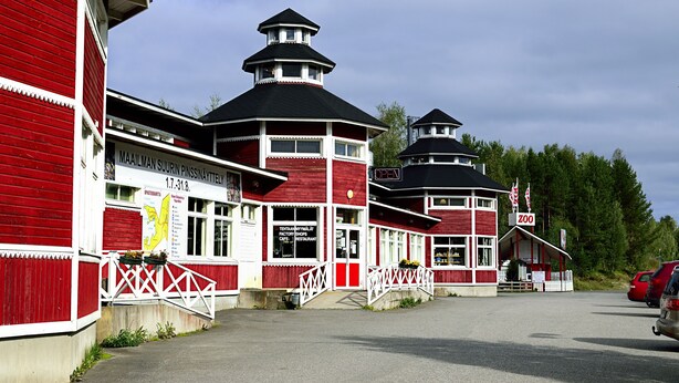 A red and white building with multiple levels and a prominent tower. - Hotel PajarinHovi (Kitee)