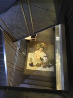A staircase with a mural of a classical figure holding a bowl and fruits.