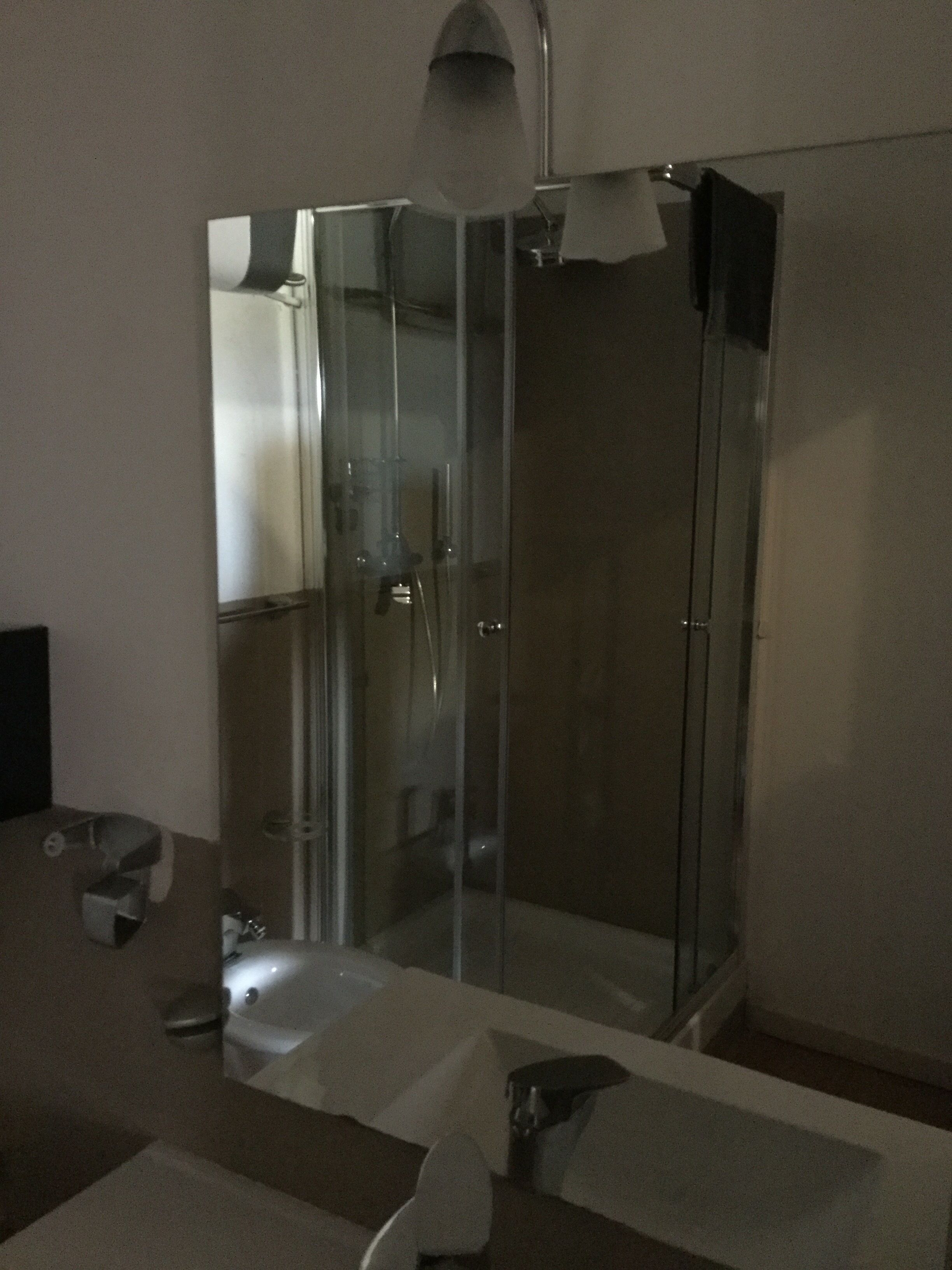 A modern bathroom with a glass-enclosed shower, a bathtub, and a toilet.