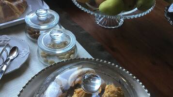 Um buffet de café da manhã com diversas opções de comida, incluindo doces, frutas e biscoitos.