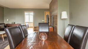 A dining area with a wooden table, six leather chairs, and a geometric glass centerpiece.