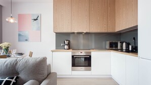 Una cocina moderna con armarios de madera, horno empotrado y microondas.