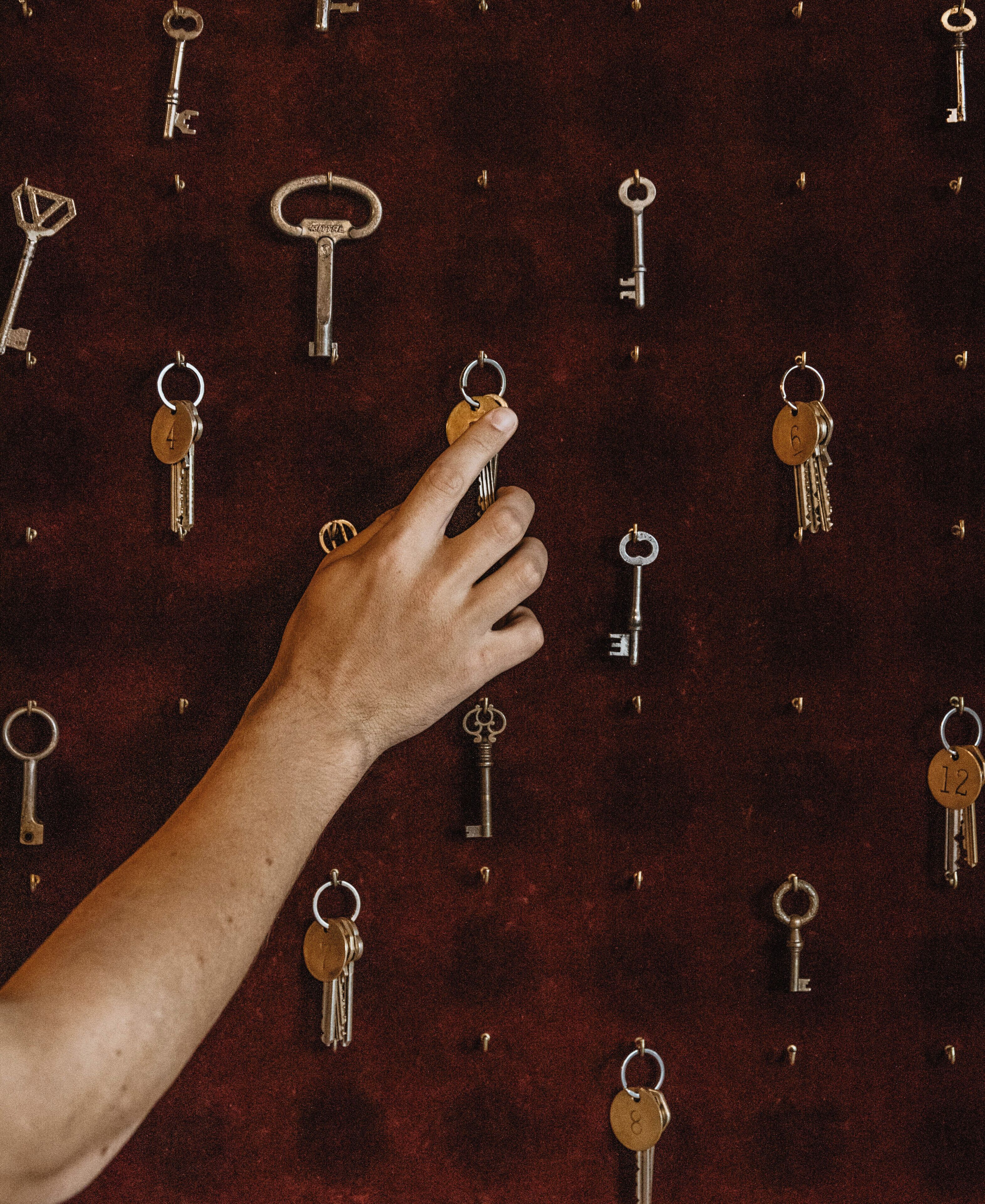 Een hand die een sleutel uit een sleutelgat in de muur pakt.