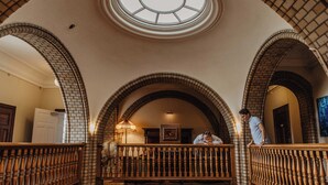 Un gran salón con techos abovedados y una escalera central.