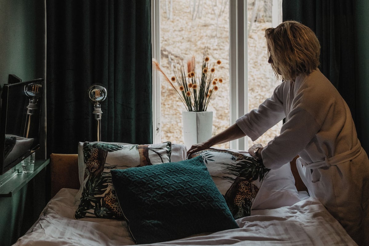 Une chambre à coucher avec un lit, une fenêtre et une plante en pot.