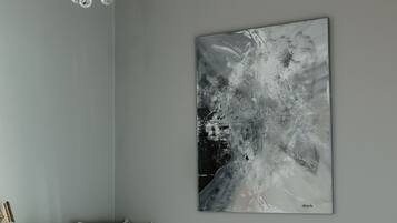 Une chambre à coucher avec un lit, un lustre et une œuvre d’art murale.
