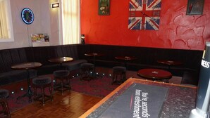 Un área de descanso con asientos y mesas, un reloj e una bandera del Reino Unido en la pared.