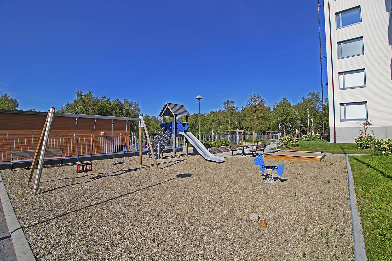 A playground with a slide, swings, and a climbing structure.