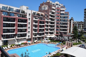 Un hôtel moderne doté d’une piscine sur le toit, de nombreux balcons et d’espaces extérieurs aménagés pour se détendre.