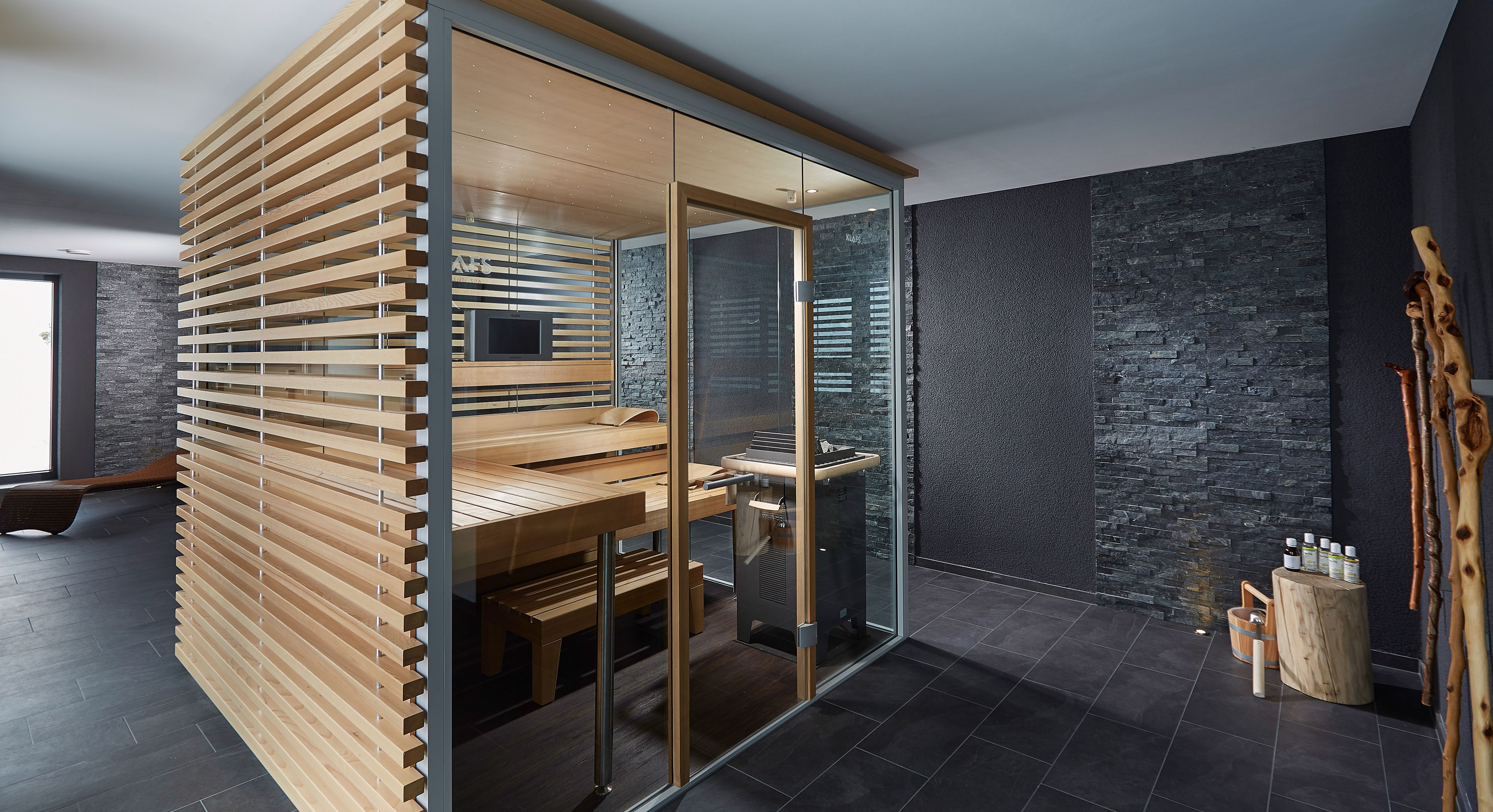 A modern bathroom with a wooden slatted partition, a glass shower enclosure, a stone wall, and a wooden bench.