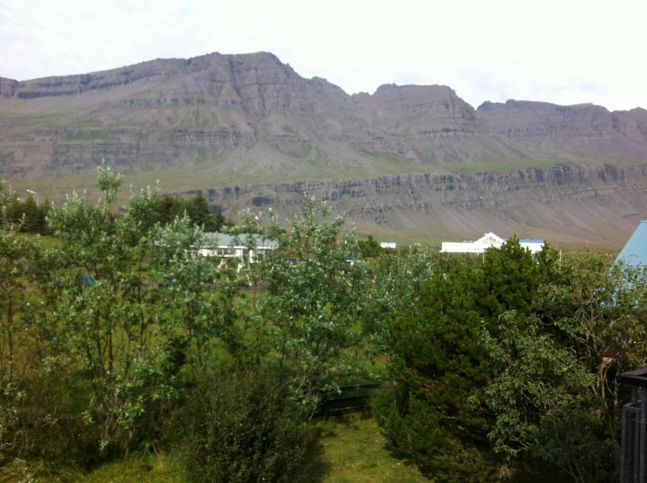 A mountainous landscape with a building in the foreground.