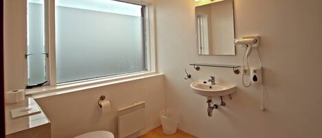Un baño con inodoro, lavamanos y ventana.