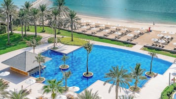 Una piscina al aire libre, sillones reclinables de piscina