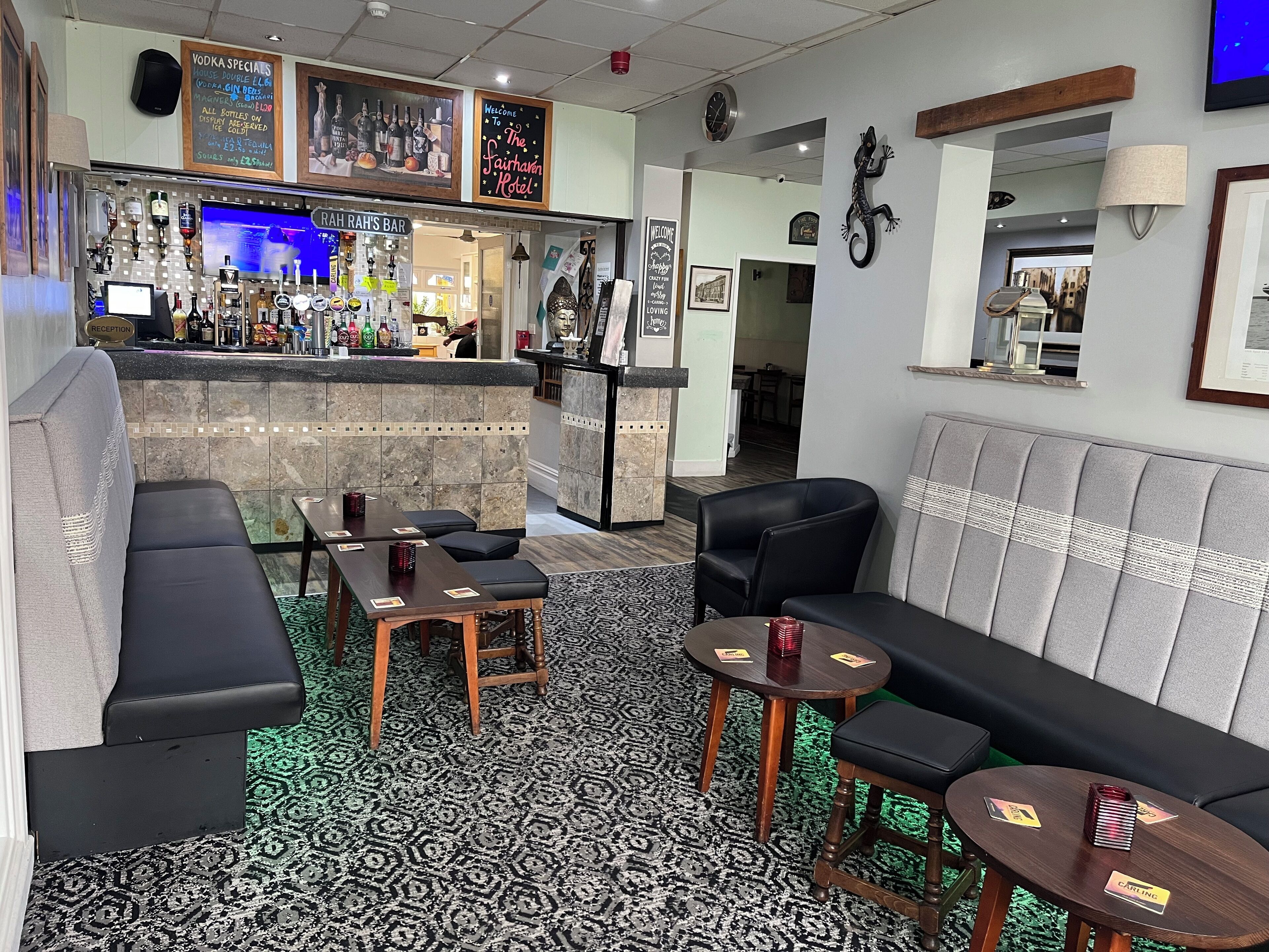 Zona de bar amb una taquilla, zones d'estar i una catifa estampada.
