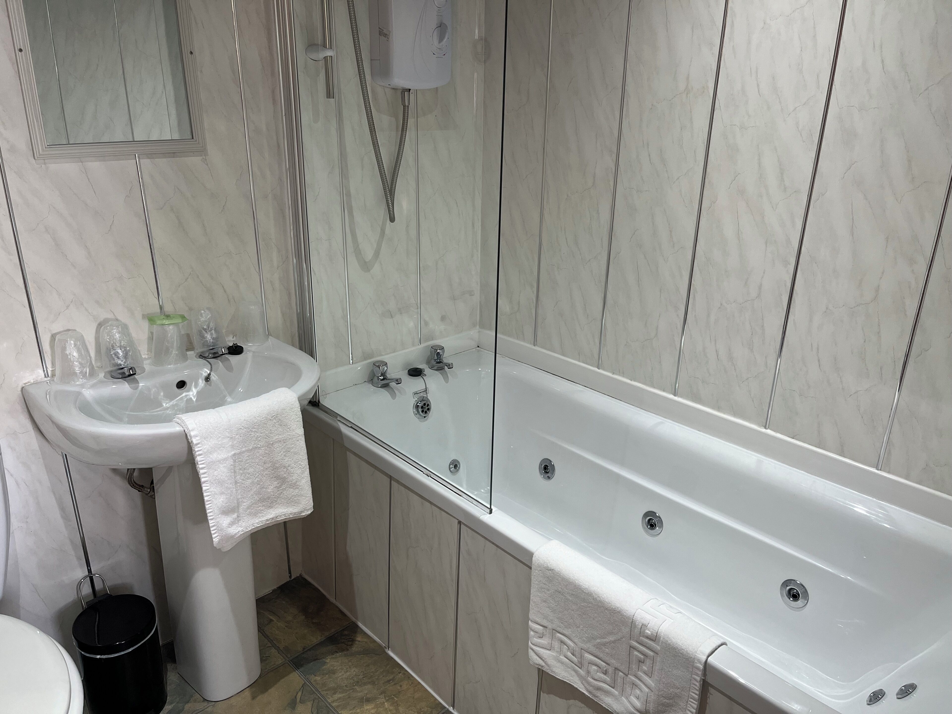A bathroom with a white sink, a bathtub, and a toilet.