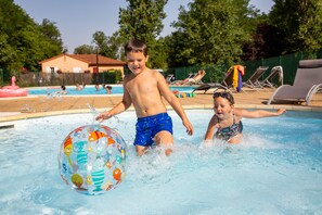 Een seizoensgebonden buitenzwembad en parasols bij het zwembad