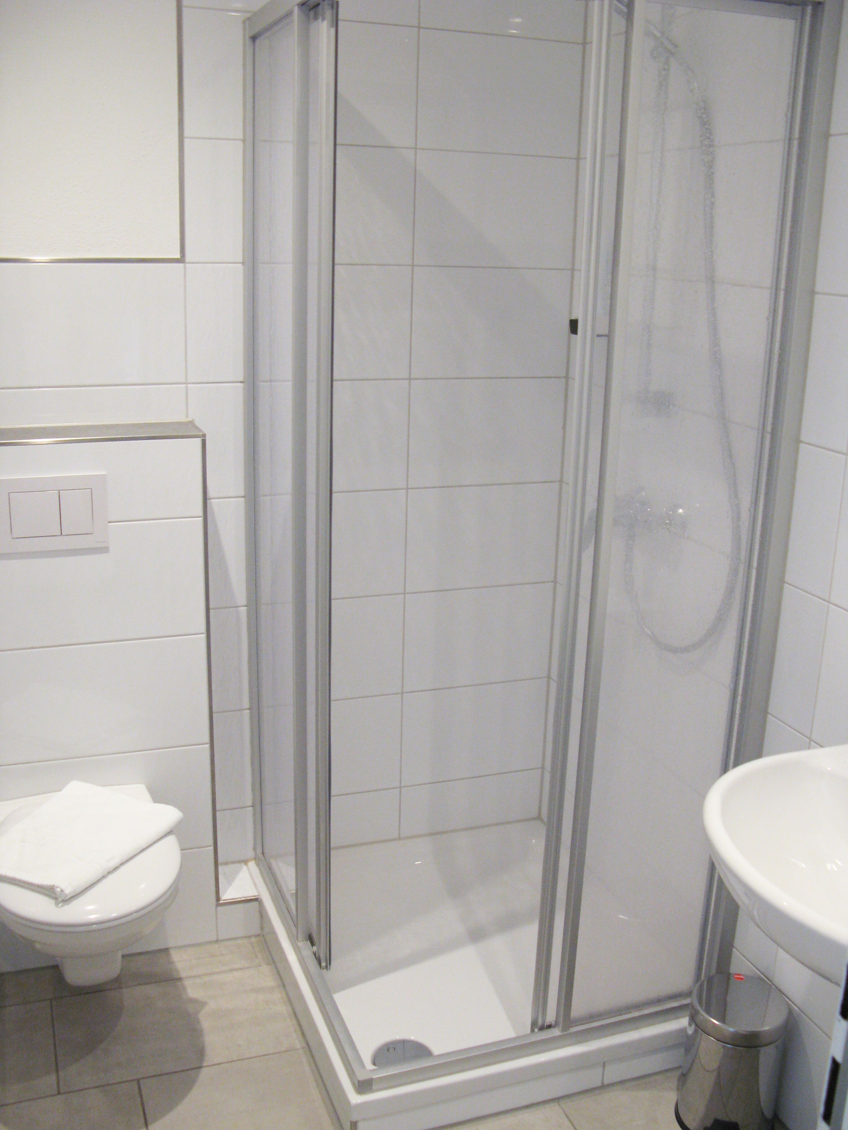 Une salle de bain avec une douche à parois de verre, des toilettes et un lavabo.