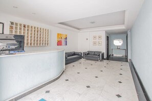 A reception area with a counter, seating, and artwork on the walls. - PIP201 Cozy flat in Boa Viagem 4 people. (Recife)