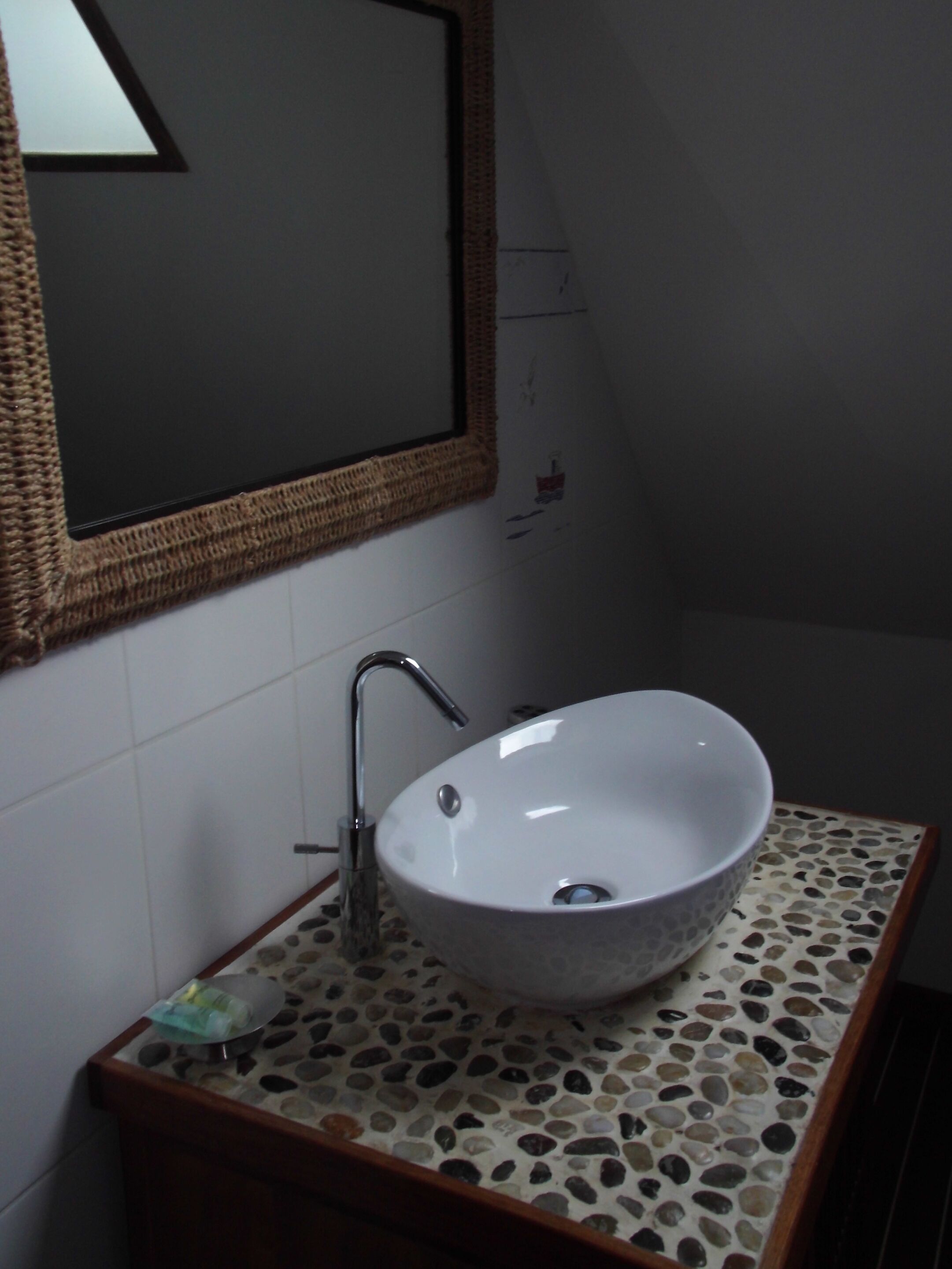 A bathroom with a white sink, a mirror, and a tiled floor.