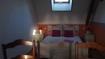 Une chambre avec un lit simple, deux tables de chevet, une commode, une fenêtre et une chaise.