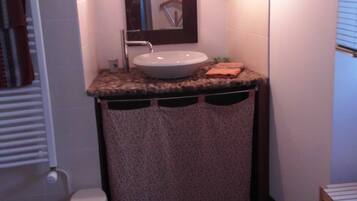 A bathroom with a sink, mirror, and toilet.