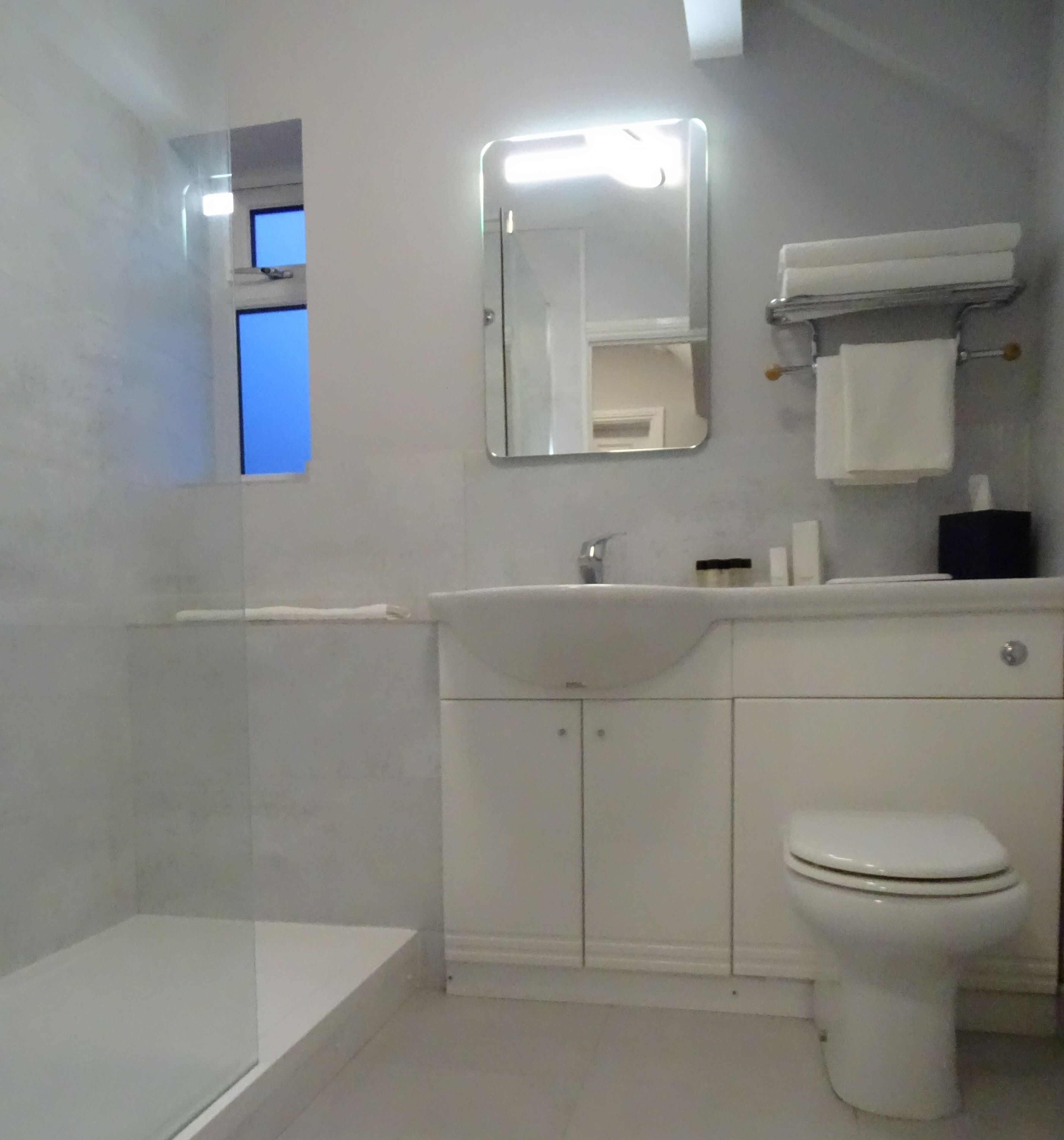 A bathroom with a bathtub, a sink, a toilet, and a mirror.