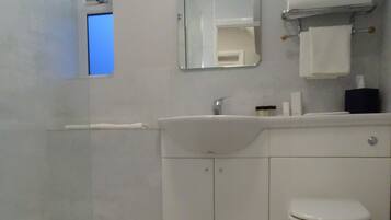 A bathroom with a bathtub, a sink, a toilet, and a mirror.
