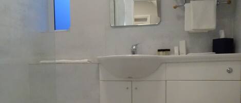 A bathroom with a bathtub, a sink, a toilet, and a mirror.