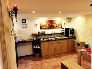 A kitchen with a coffee machine, a toaster, and a fruit display. - Europa Pension zum grünen Baum (Rust)