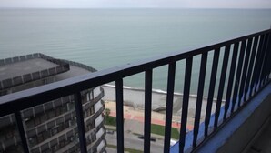 A balcony with a view of the sea and a road with vehicles. - KNJZ Seaview Apartment (Batumi)