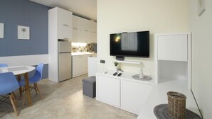 A modern kitchen with white cabinets, a built-in oven, and a flat-screen TV mounted above the counter. - KNJZ Seaview Apartment (Batumi)