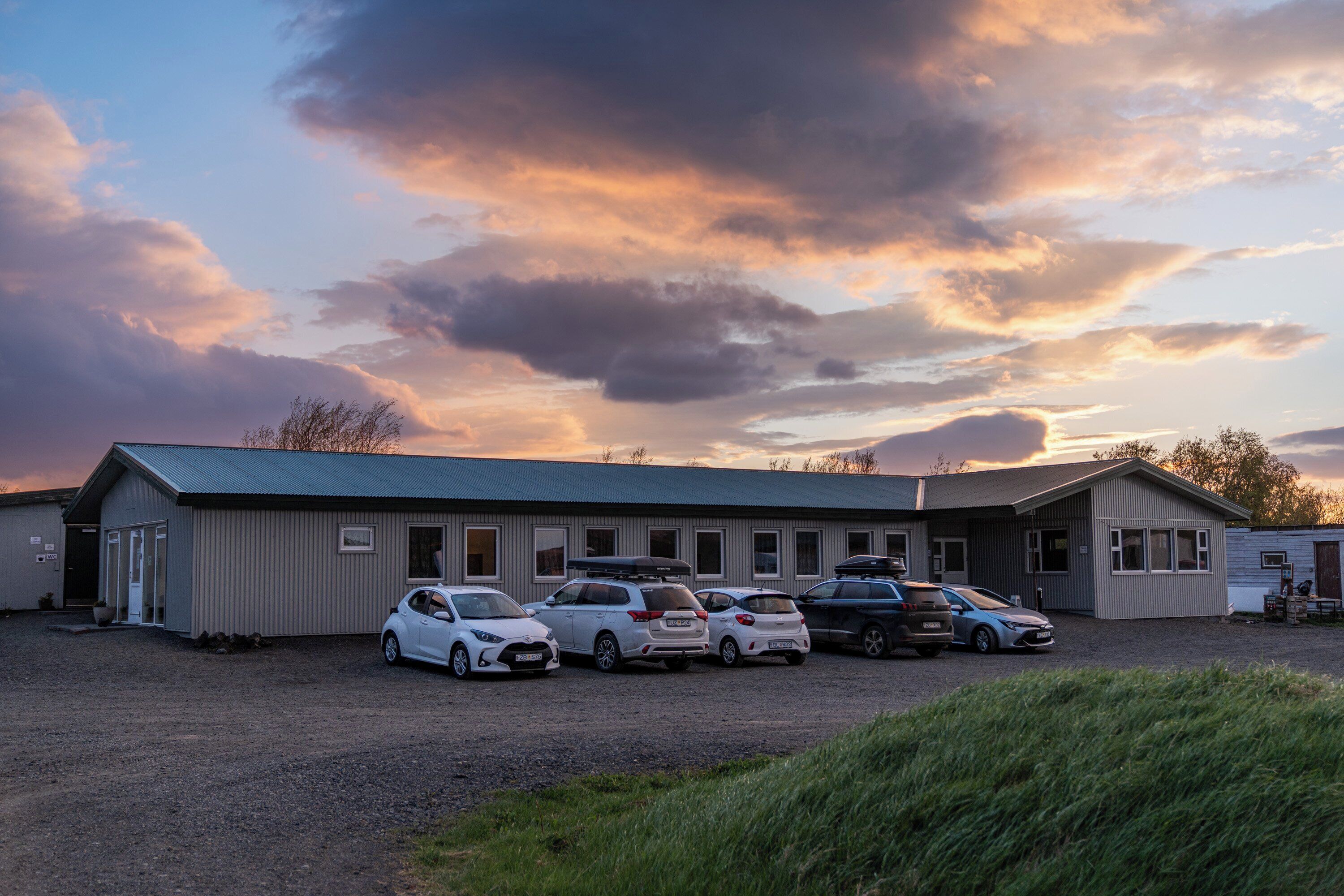 A building with multiple cars parked in front.