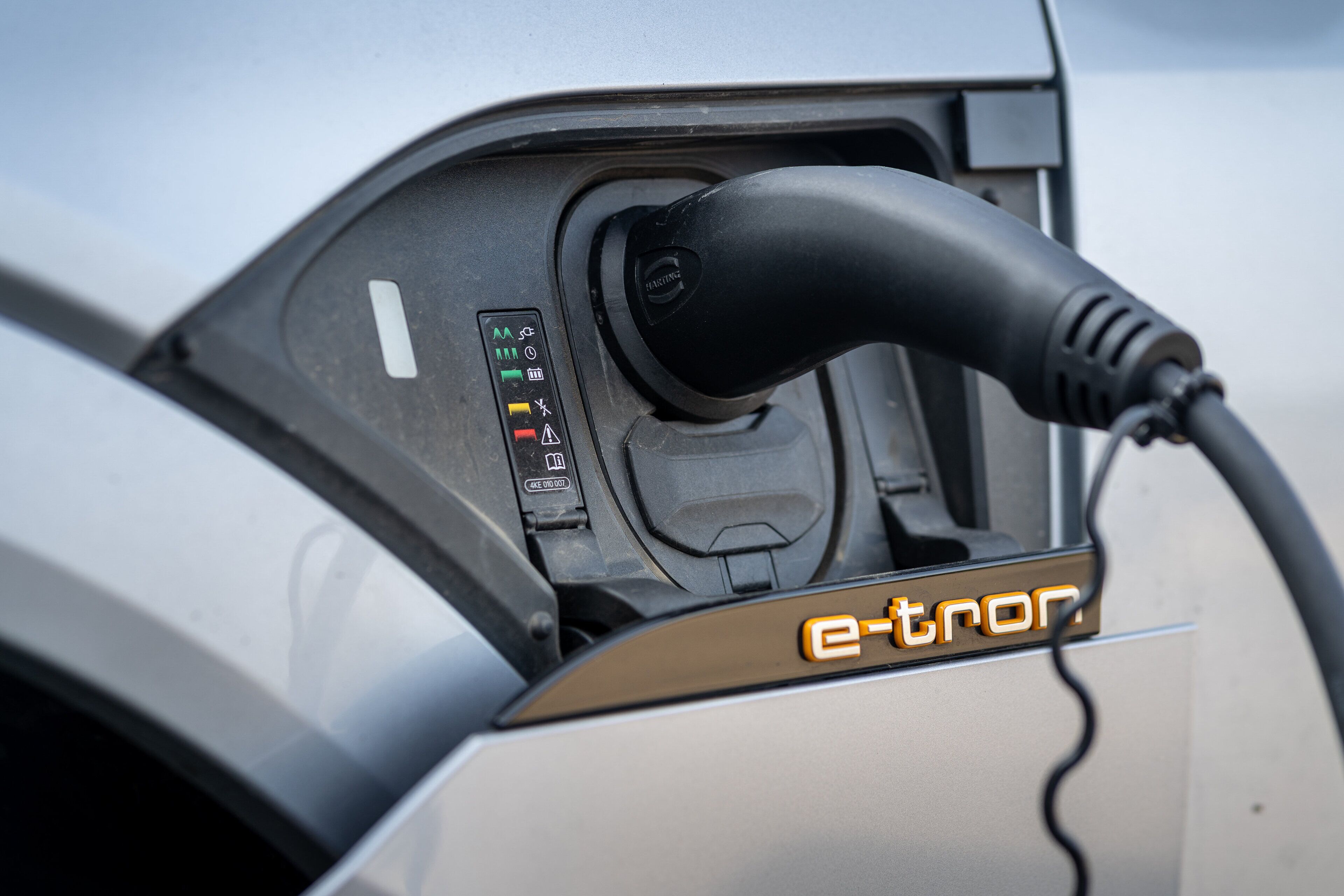 An electric vehicle charging station with a plug and a control panel.
