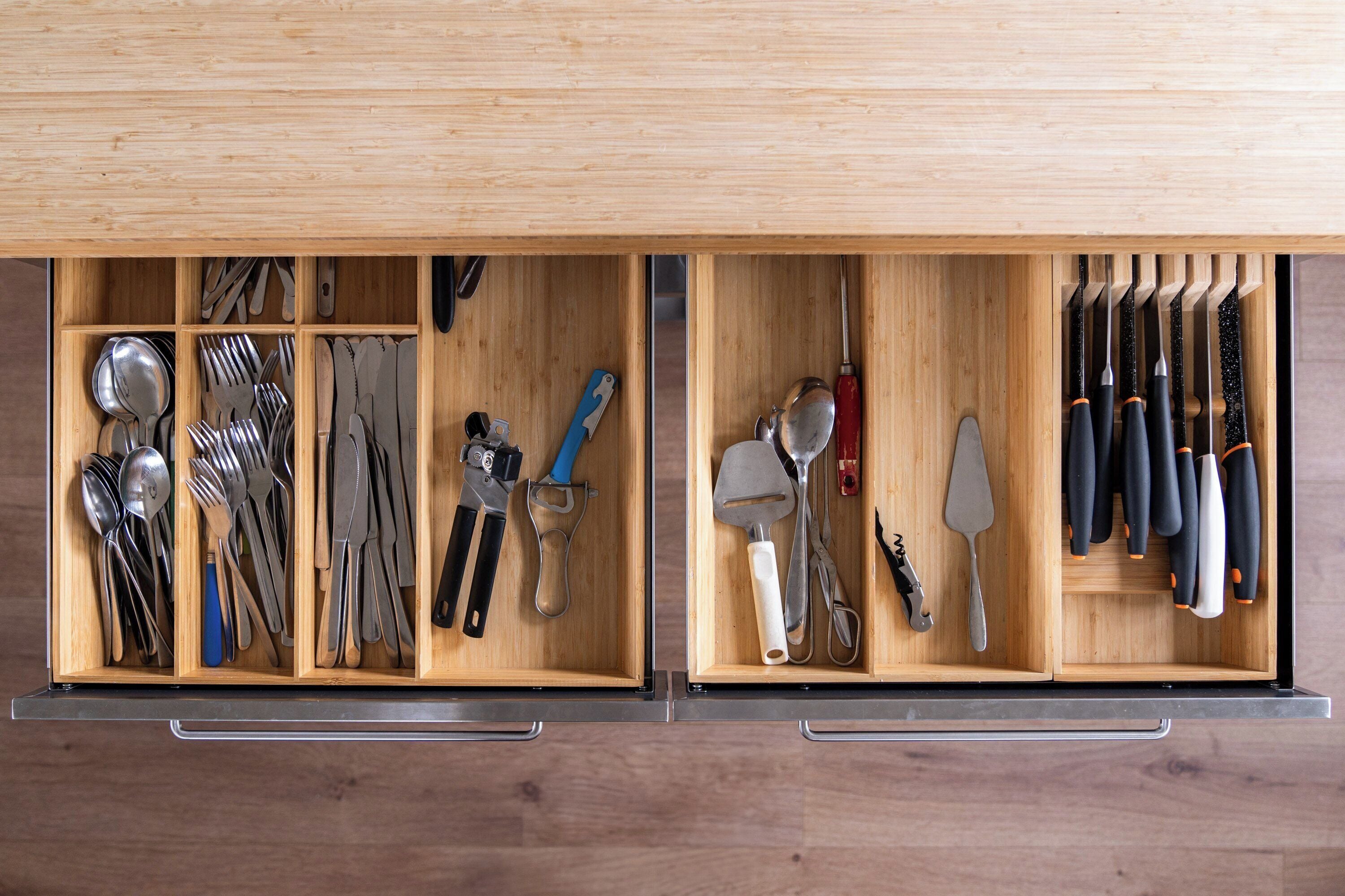 A drawer with neatly organized kitchen utensils, including spoons, forks, knives, and spatulas.