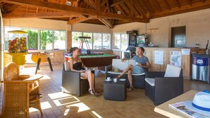 A pool area with wicker furniture, a pool table, and a bar. - Camping de Saulieu (Saulieu)