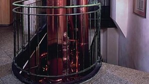 A copper cylindrical structure with a glass enclosure, situated in a room with arched ceilings and a staircase. - Altstadt Hotel Bräu Wirt (Weiden in der Oberpfalz)