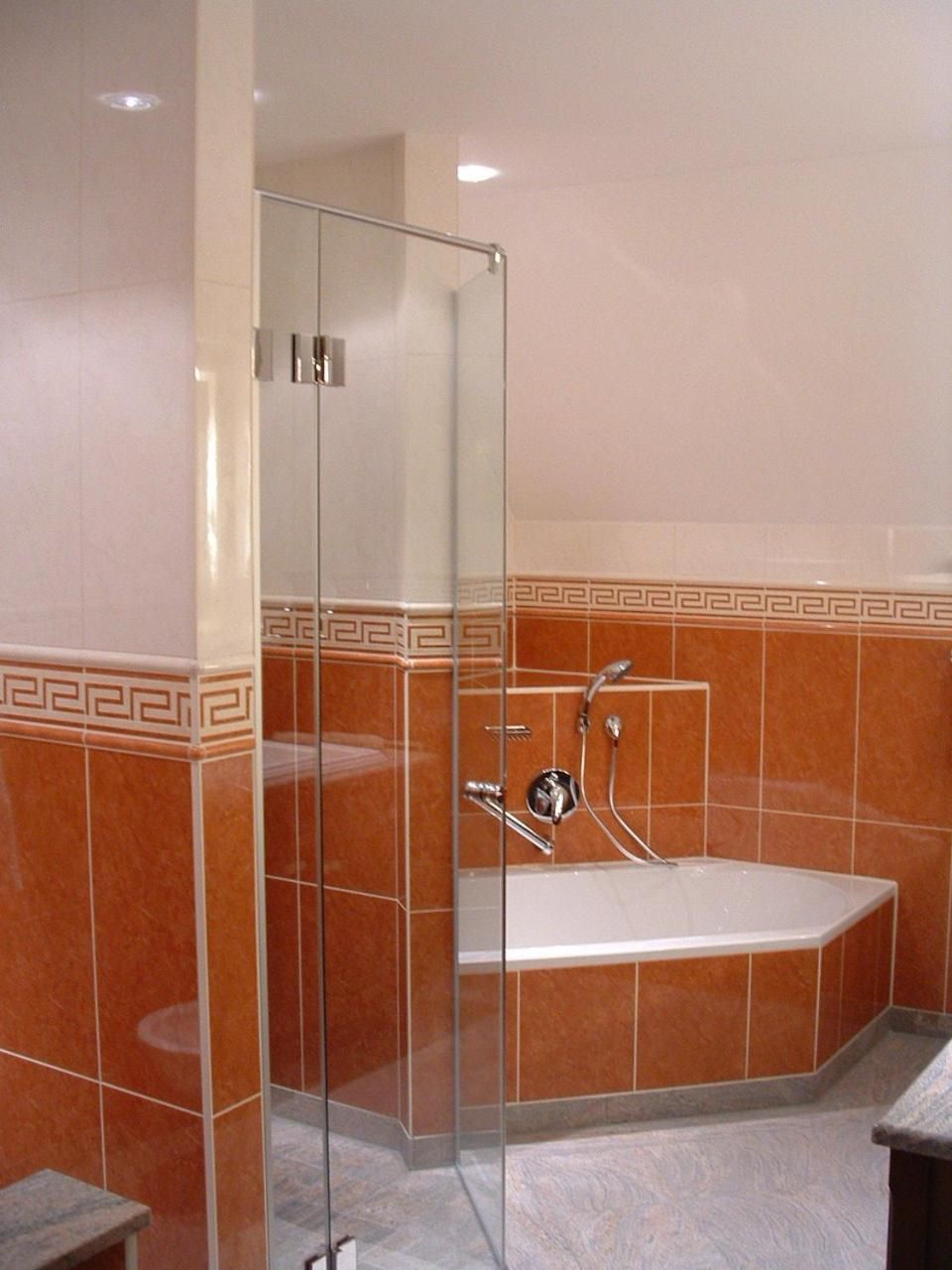 Ein Badezimmer mit einer gläsernen Duschkabine, einer Badewanne und einem Marmorboden.