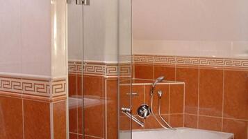 Ein Badezimmer mit einer gläsernen Duschkabine, einer Badewanne und einem Marmorboden.