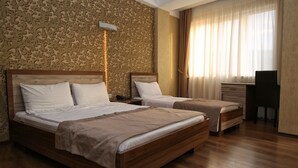 Una habitación de hotel con dos camas de madera, un escritorio y una silla.