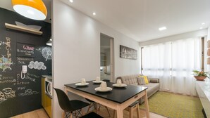 A modern living room with a dining area, a sofa, a coffee table, and a blackboard with various writings. - Excelente flat em Setúbal, Boa Viagem 1Q 3 pessoas. Conforto e ótima localização PM802 (Recife)