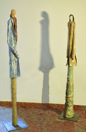 Two statues with detailed clothing and a shadow on a plain wall. - Art Home B&B (Carcassonne)